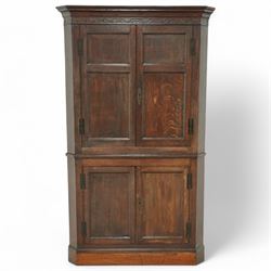 18th century oak corner cupboard, moulded cornice over four panelled doors, on plinth base